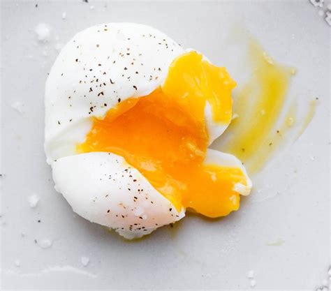Représentation d'un œuf mollet coupé en deux, montrant le blanc cuit et le jaune coulant