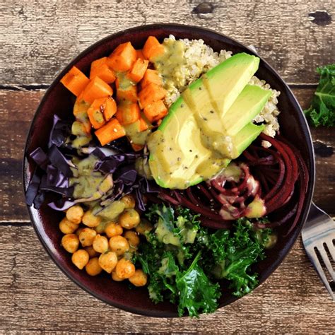 Composition d'un buddha bowl coloré avec des pois chiches, des patates douces, des légumes verts et des graines