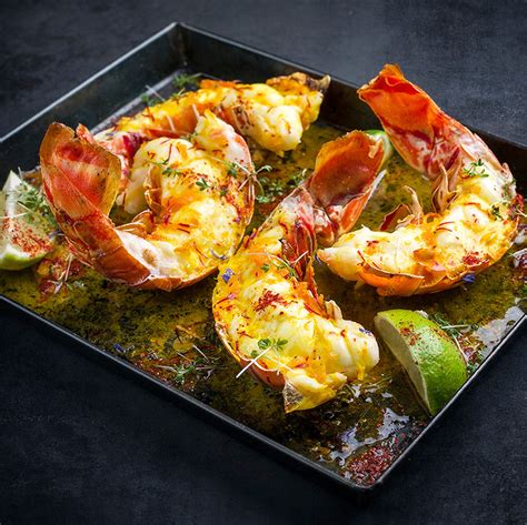 Illustration d’un plateau de langoustes flambées avec patates douces et agrumes