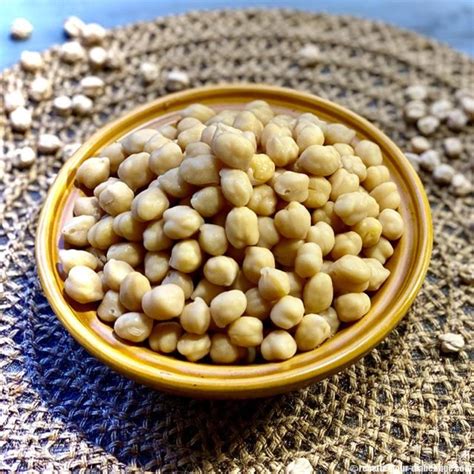 Image d'une personne rinçant des pois chiches secs sous un robinet