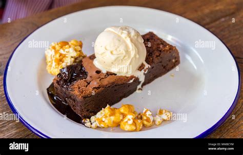 Brownie servi avec une boule de glace vanille et un coulis de framboise