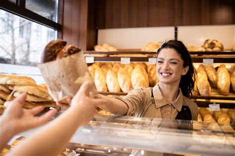 Personnel souriant servant des clients à un comptoir de boulangerie