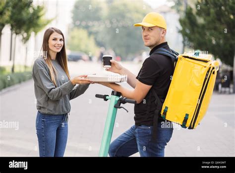 Un livreur souriant remettant une pizza chaude