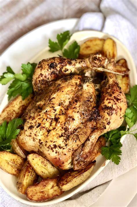 Image d’une cocotte avec poulet citron romarin entouré de pommes de terre et légumes