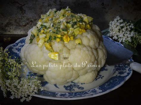 Un chou-fleur entier posé sur un plat de service, avec de la vinaigrette et des œufs émiettés