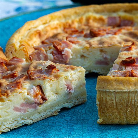 Une quiche lorraine coupée en part, révélant sa texture épaisse et moelleuse