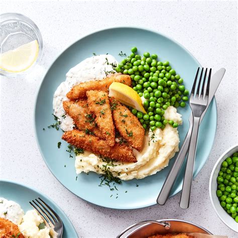 Assiette de céleri-rave pané avec purée de petits pois et quartiers de citron