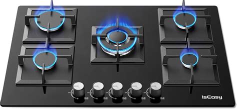 Gros plan sur une plaque de cuisson à gaz en acier inoxydable avec des brûleurs allumés