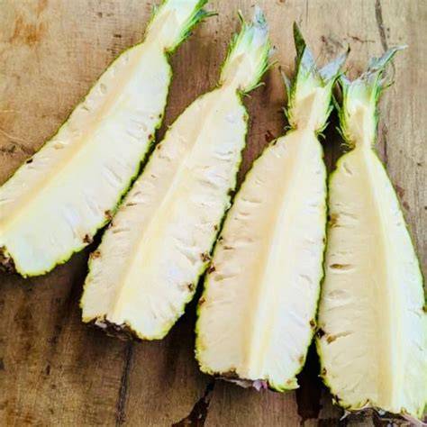 ananas pain de sucre tranché sur planche en bois