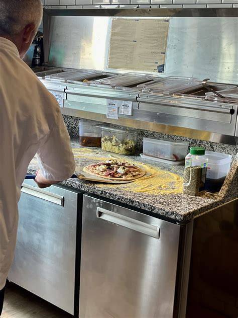 Cuisine et préparation des pizzas artisanales à Chrono Pizza