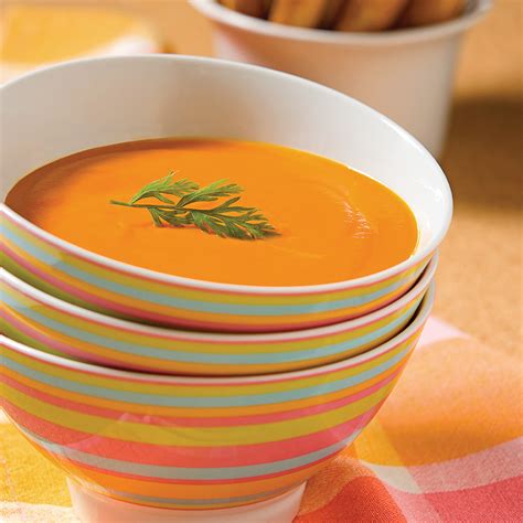 Bol de velouté de carottes décoré de feuilles de cerfeuil et d'un filet d'orange