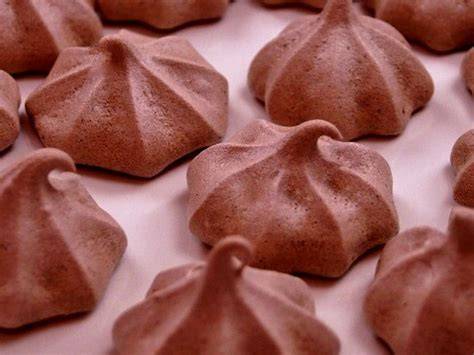 Petite plaque de meringues au chocolat posées sur papier sulfurisé