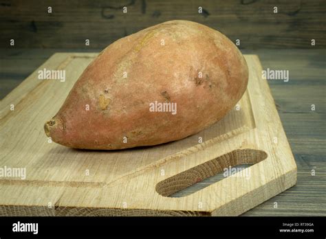 Une patate douce lavée sur une planche à découper