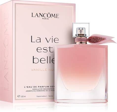 Illustration d'une bouteille de La Vie Est Belle Vanille Nude dans un décor de pâtisserie lumineuse