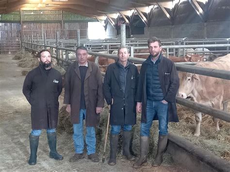Un éleveur discutant avec un marchand de bestiaux devant une ferme