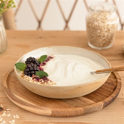 Un bol de skyr crémeux à côté de fruits rouges frais