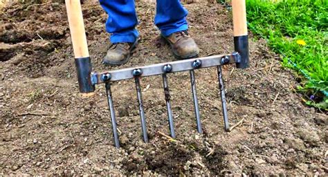 Jardinier travaillant la terre avec une grelinette