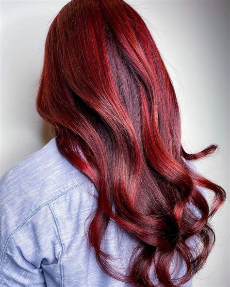 Cheveux courts avec un balayage praline rouge vif et mèches violettes