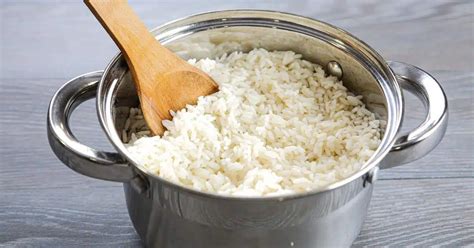 Une poêle avec du riz en train de cuire, avec du bouillon ajouté