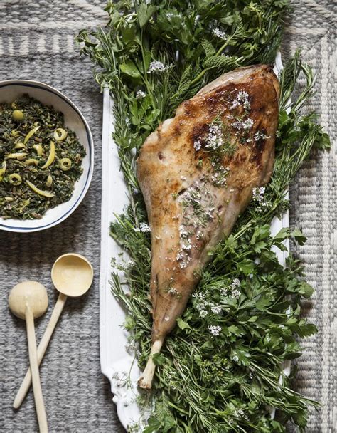 Gousses d'ail et brins de thym sur un gigot d'agneau cru