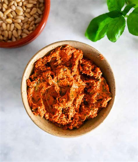 Bol de pesto rosso fait maison avec des tomates séchées, de l'ail, des noix et de l'huile d'olive